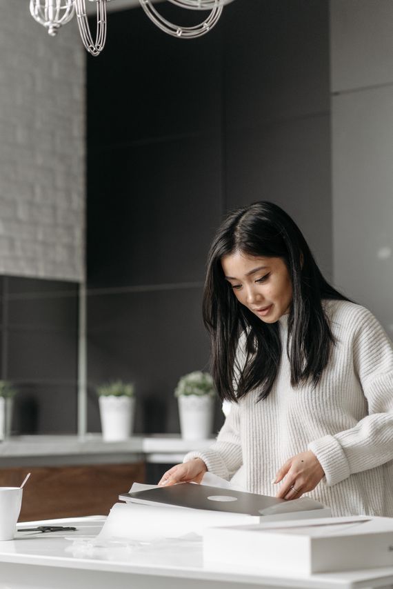 Customer opening an online order package in a modern kitchen