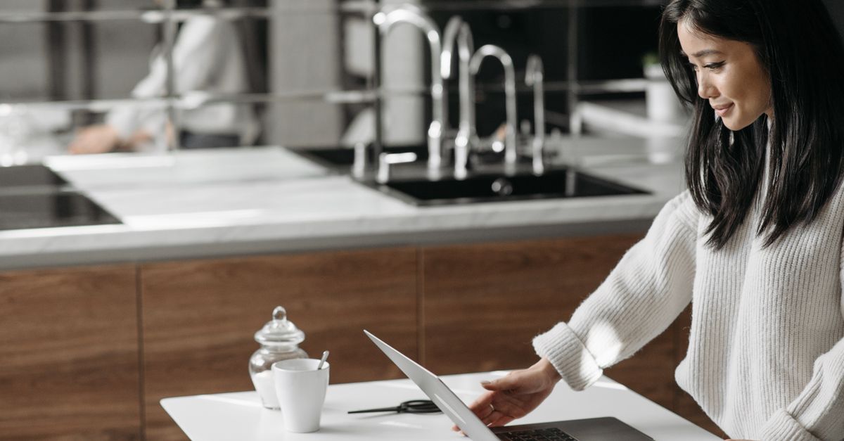 person working on laptop at kitchen table evening