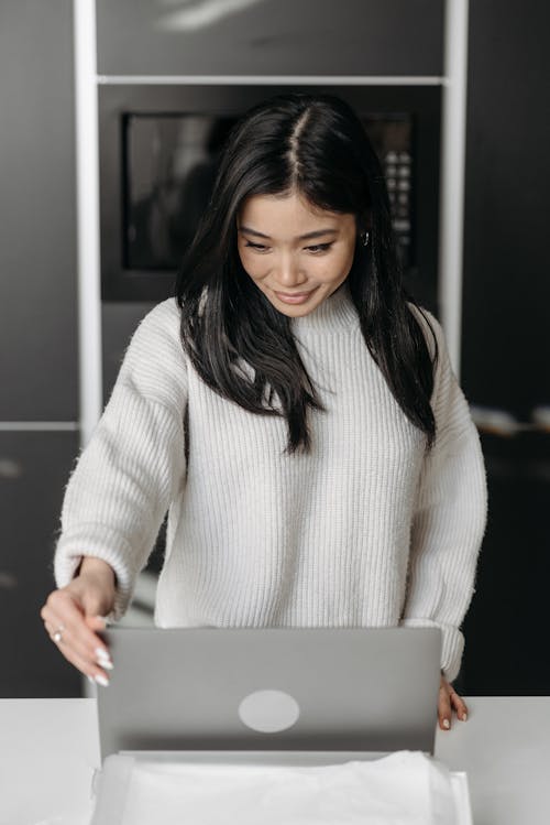 Woman Smiling While Holding a Macbook Pro Laptop 