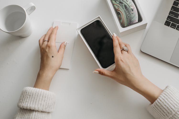 A Person Holding A Phone In The Box