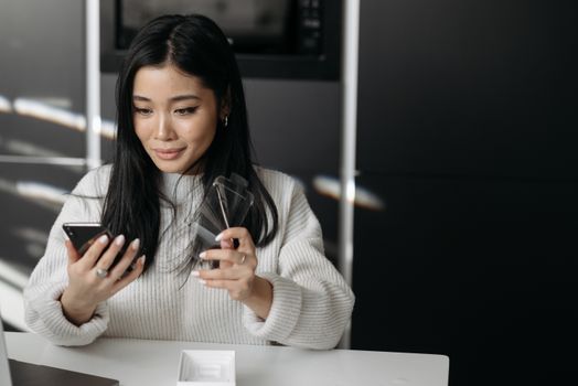 Woman unpacking and setting up a new smartphone device indoors.