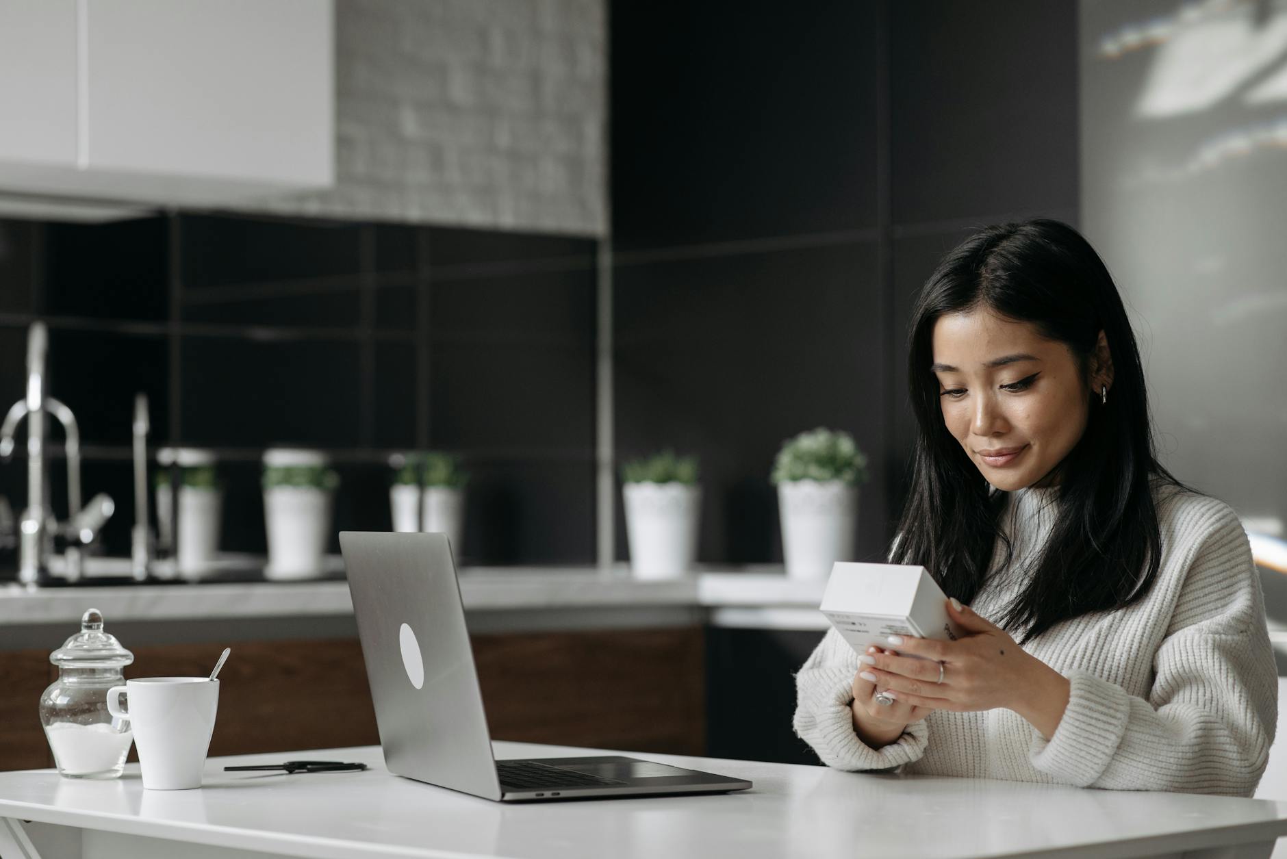 https://www.pexels.com/photo/woman-sitting-beside-white-table-holding-white-box-7190930/