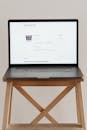 Gray Laptop on Brown Wooden Stool