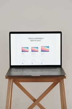 Laptop on a wooden stand with screen showing notebook comparison.