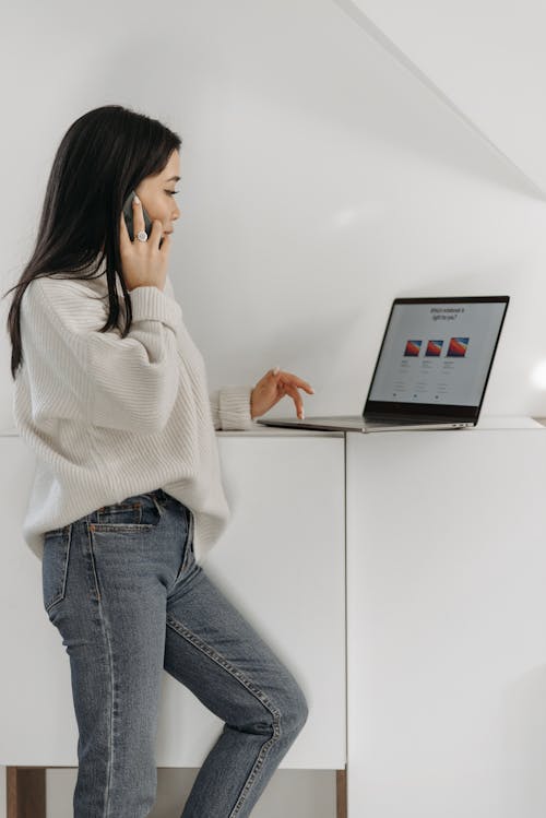 A Woman Using a Smartphone and a Computer Laptop