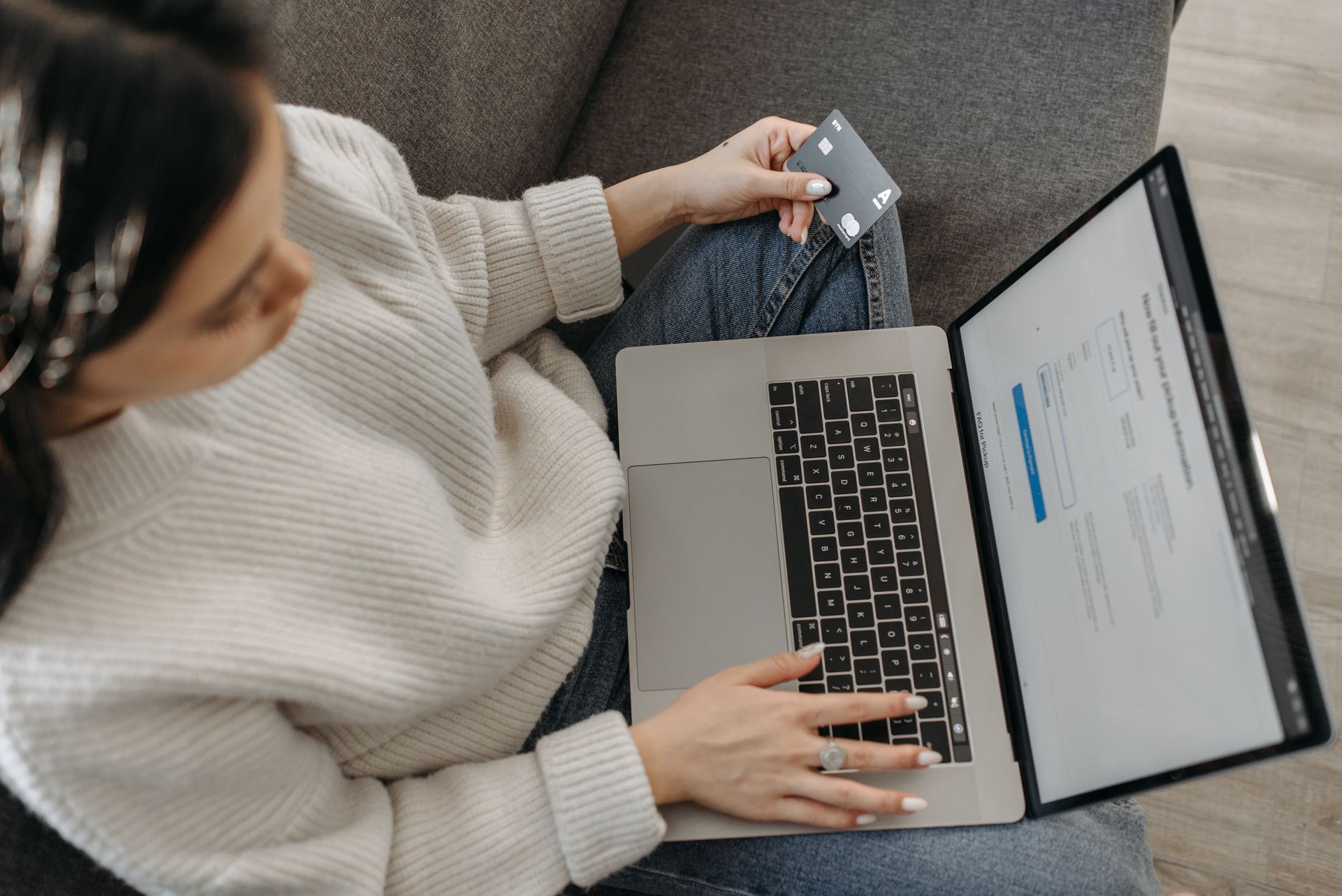 A Woman Using Her Laptop while Holding a Credit Card