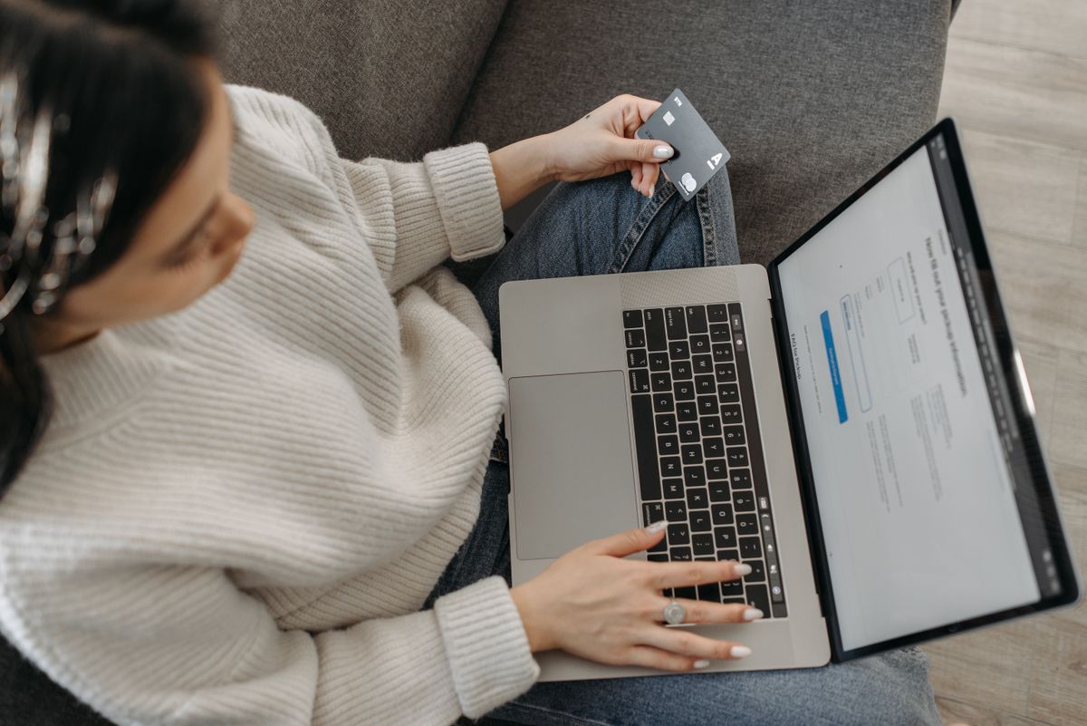 A person researching online on a laptop from the sofa