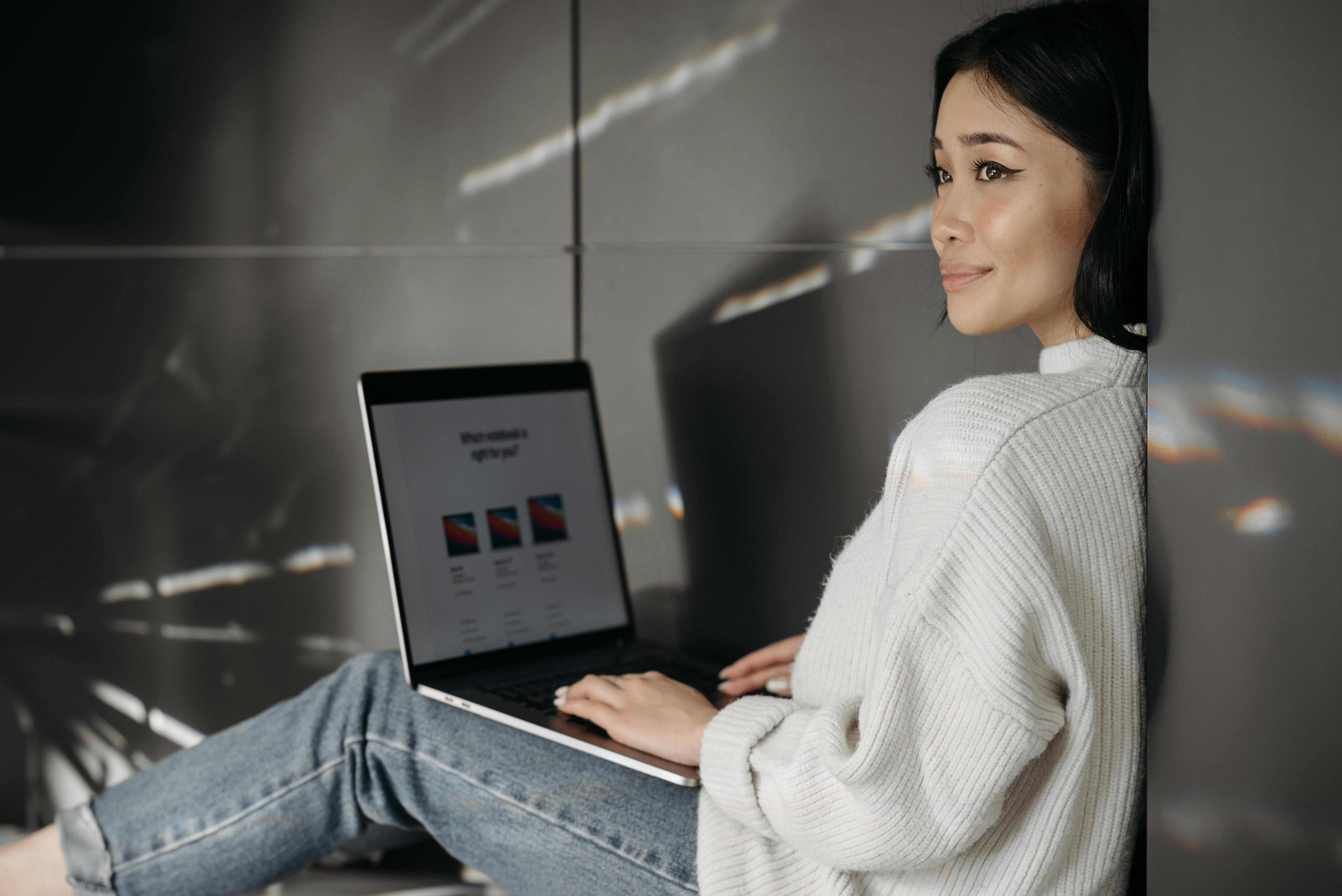 Smiling woman sitting indoors, shopping online with a laptop. Perfect for digital lifestyle themes.
