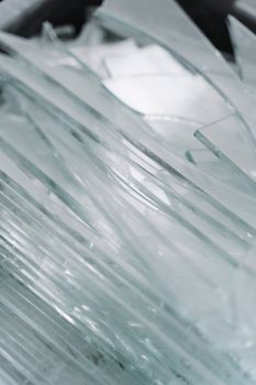 Detailed view of sharp glass pieces arranged in a pile, showcasing shattered textures.