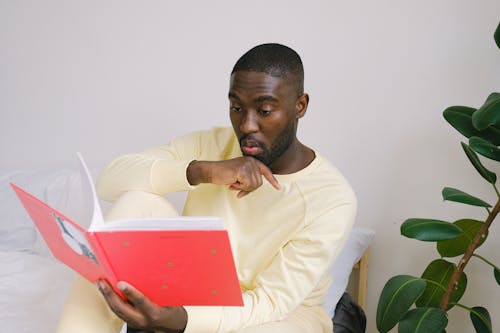 Free Surprised black student with copybook in bedroom Stock Photo