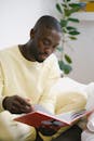 Attentive black student with notebook studying on bed