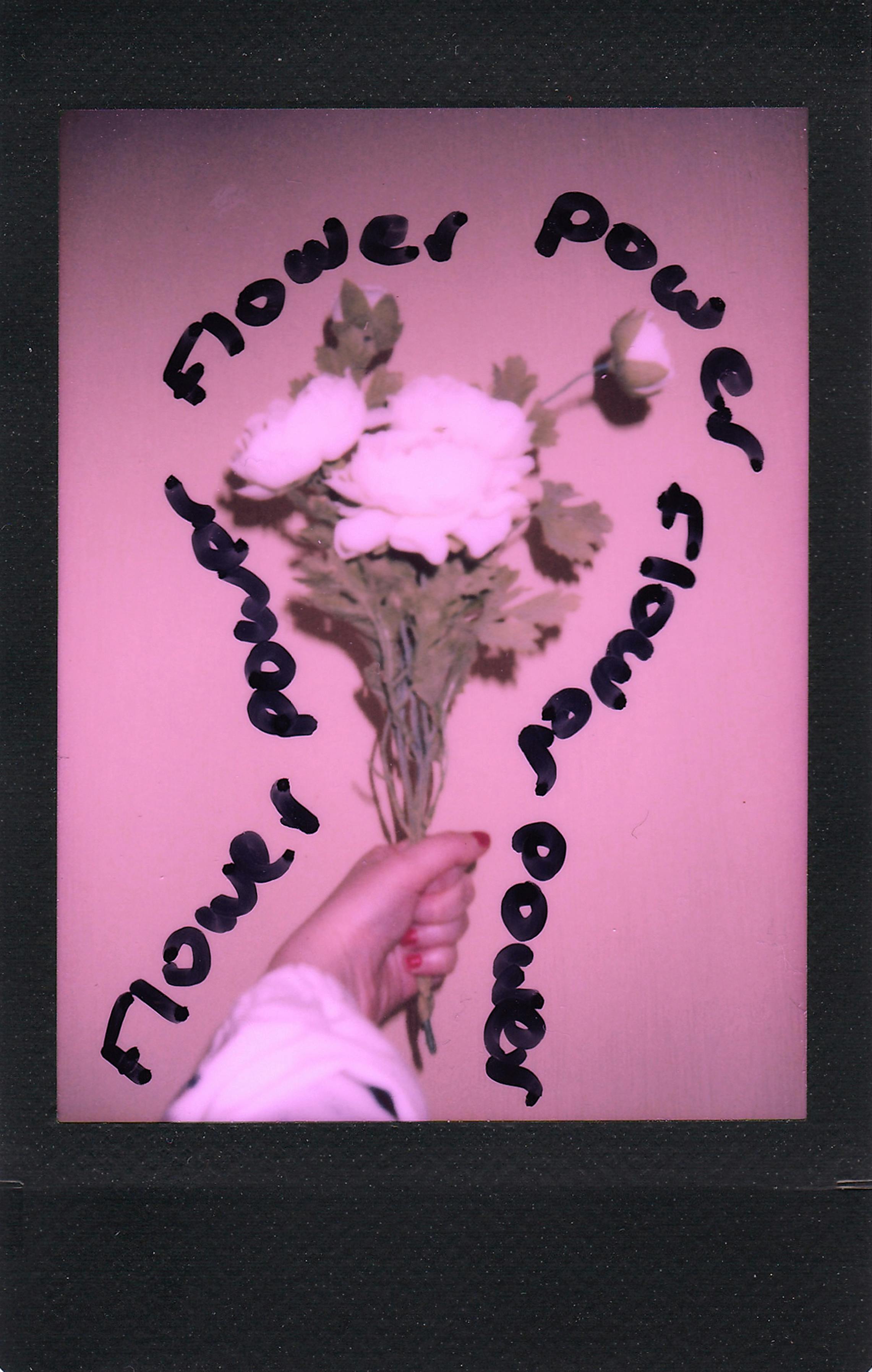 Artistic image of a hand holding a flower bouquet with the text "Flower Power."