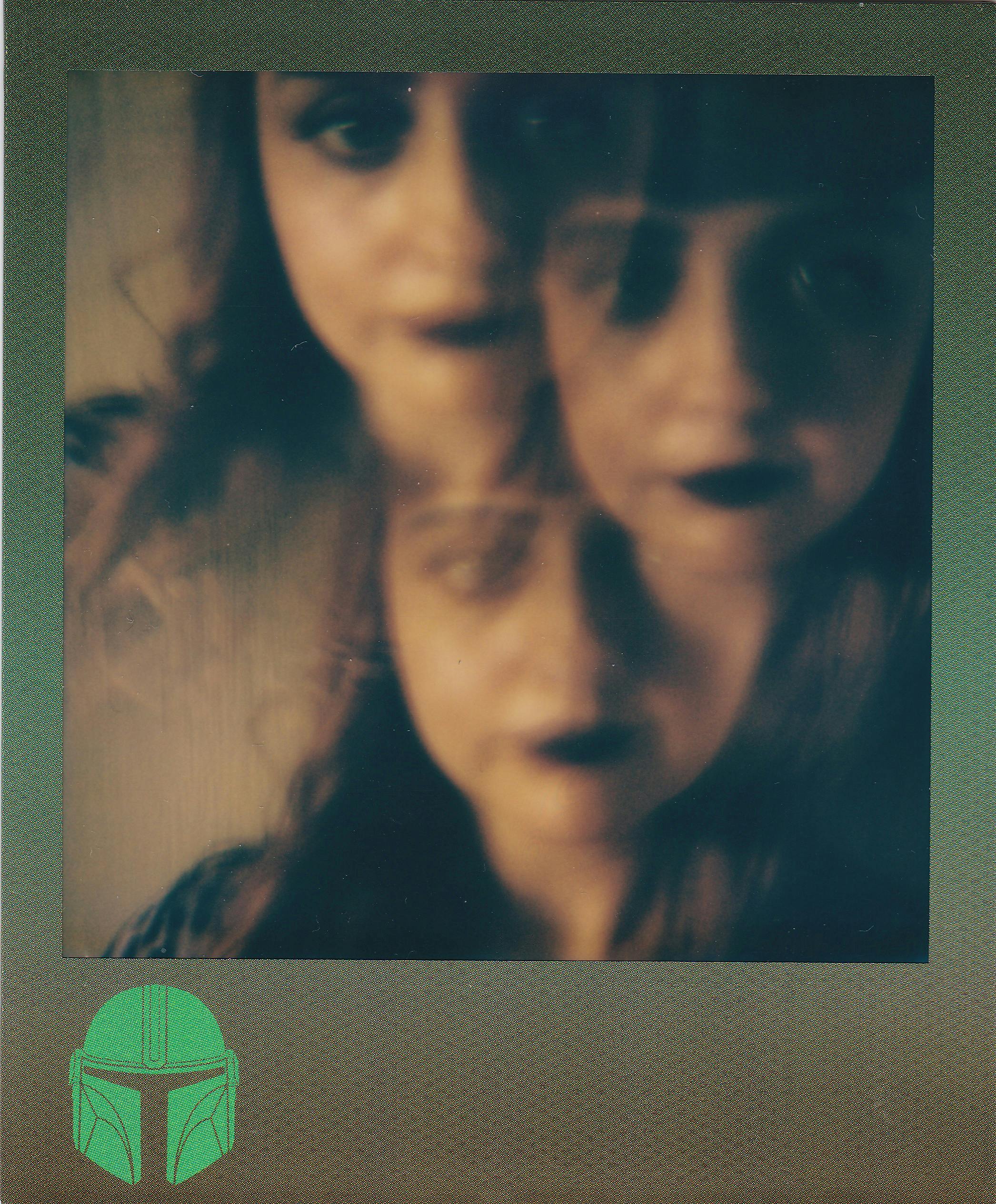 Vintage Polaroid portrait with blur and double exposure effect featuring a woman's face.