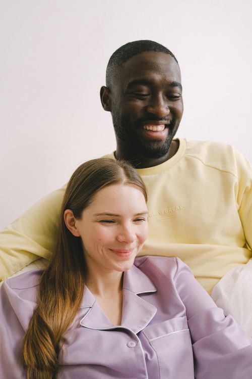 Free A cheerful interracial couple embracing indoors, showcasing affection and happiness. Stock Photo