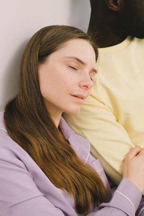 Free Woman in Purple Pajamas Sleeping on a Person's Shoulder Stock Photo