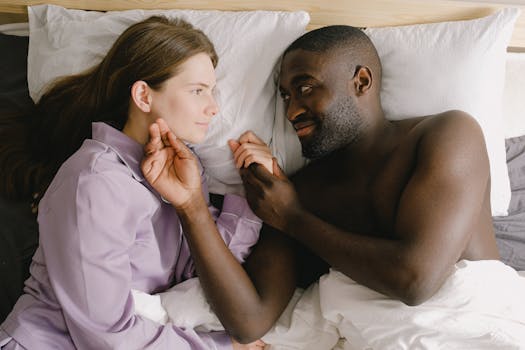 Loving couple lying in bed in relaxed morning setting. Intimate and warm atmosphere.