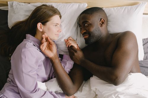 Free Loving couple lying in bed in relaxed morning setting. Intimate and warm atmosphere. Stock Photo