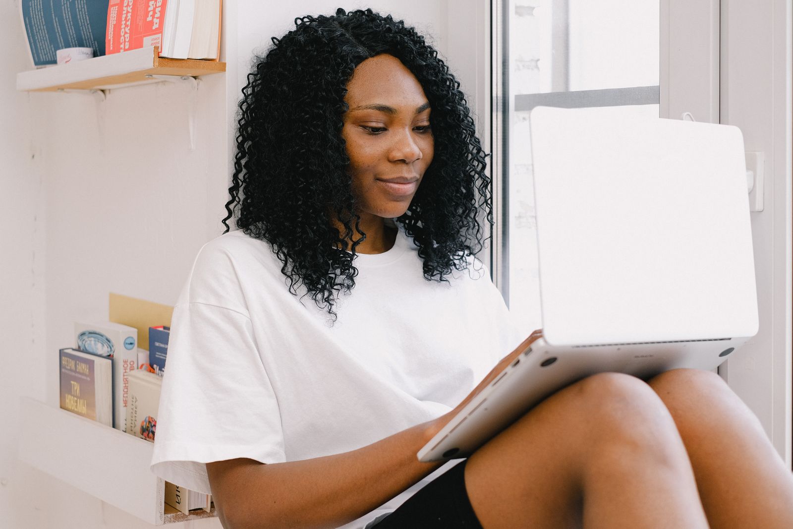 Black woman using a laptop at home to review an online application