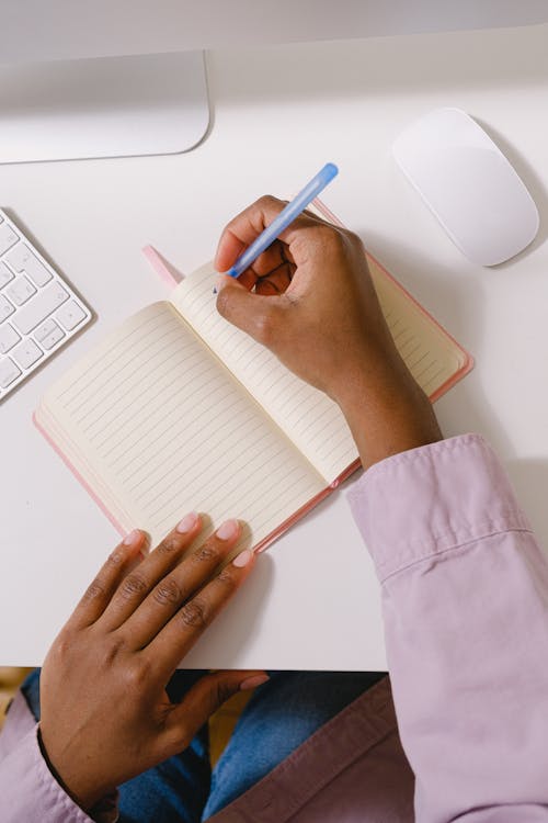 Black businesswoman taking notes in planner