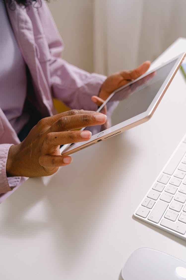 Black Woman Using Tablet At Table With Keyboard