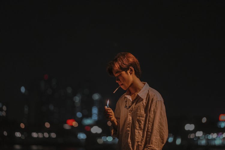 Man In Brown Shirt Smoking At Night