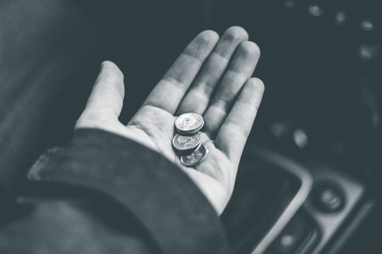 Person Holding Coins While Sitting In Car