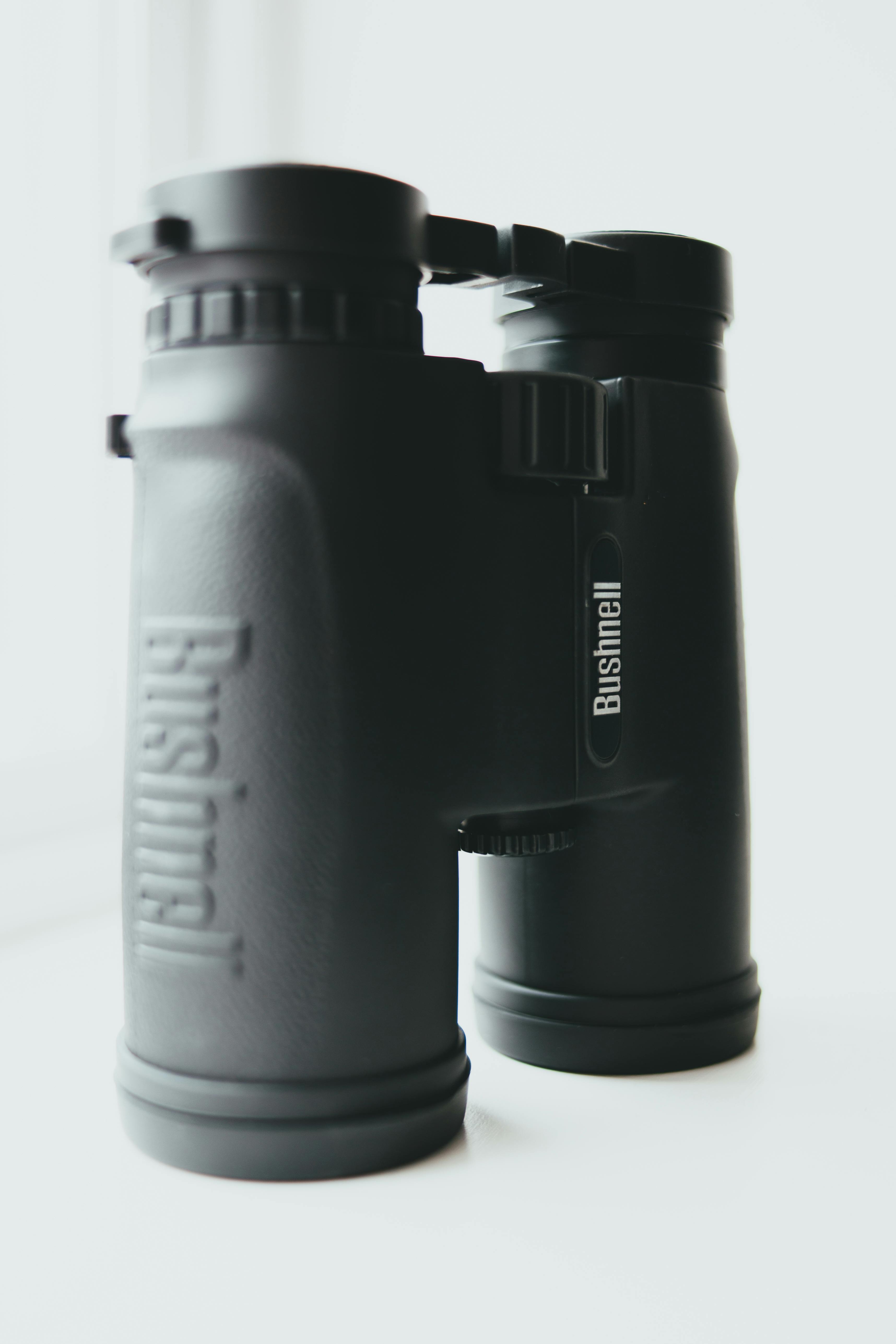 High-quality close-up of black binoculars on a white background.