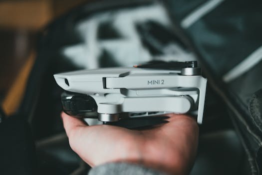 Close-up of a hand holding a modern compact drone, ideal for photography enthusiasts.