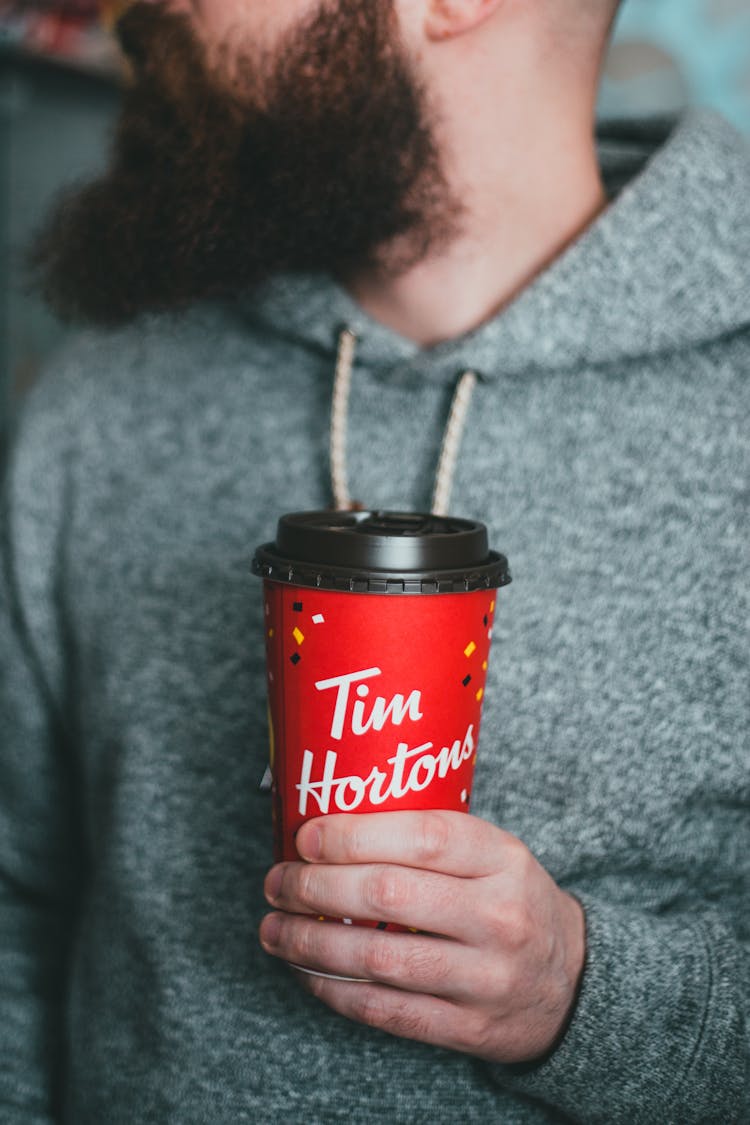 Man Holding Takeaway Coffee In Red Cup