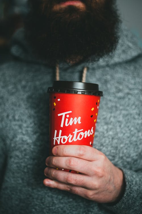 Bearded man holding cup of coffee
