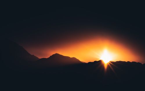 Free Silhouette of Georgian mountains with a dramatic sunset creating a glowing horizon. Stock Photo