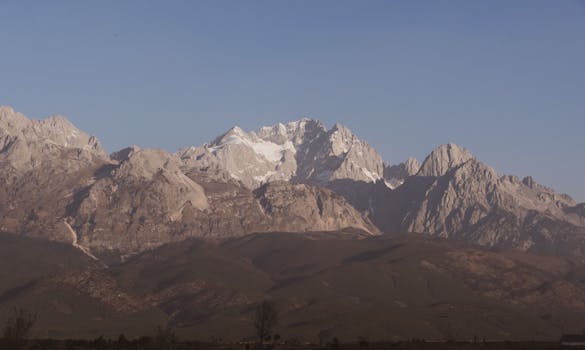 Scenic view of snow-capped mountain range against a clear blue sky, perfect for nature lovers.