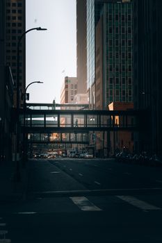 Downtown Minneapolis cityscape featuring illuminated skyscrapers and a pedestrian walkway during dusk.