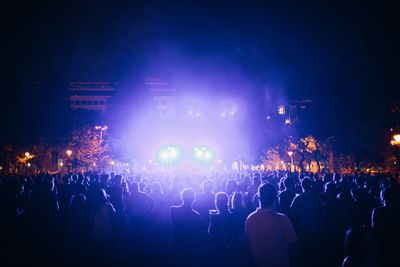 Evening concert crowd under coloured lights — photo by Bence Szemerey on Pexels