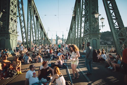 People Sitting on the Road of Liberty Bridge in Budapest