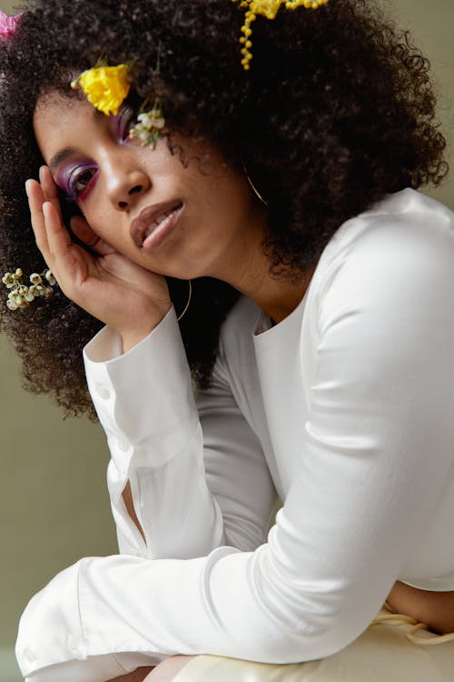 An Afro-Haired Woman in White Top Posing
