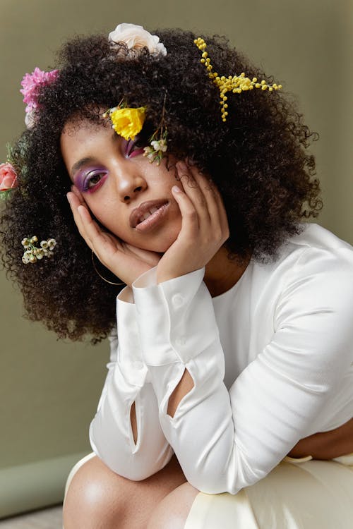 An Afro-Haired Woman in White Top Posing