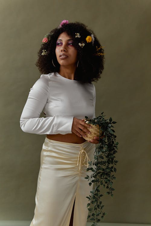 Woman in White Crop Top Holding a Potted Plant