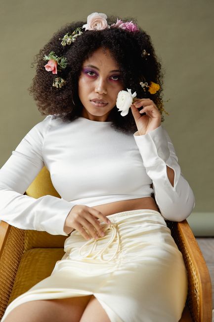 Stylish portrait of a woman with floral afro hair in a studio setting.