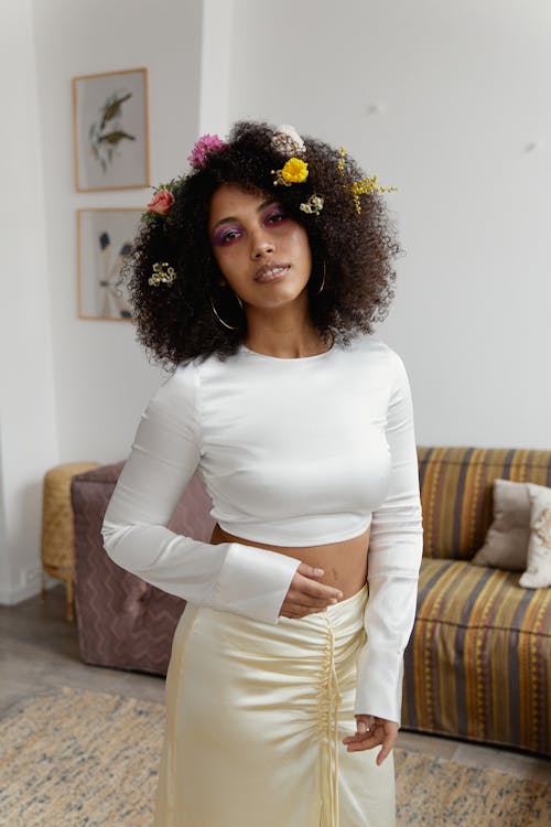 Woman in White Long Sleeve Shirt and Yellow Skirt Posing in Front of the Couch