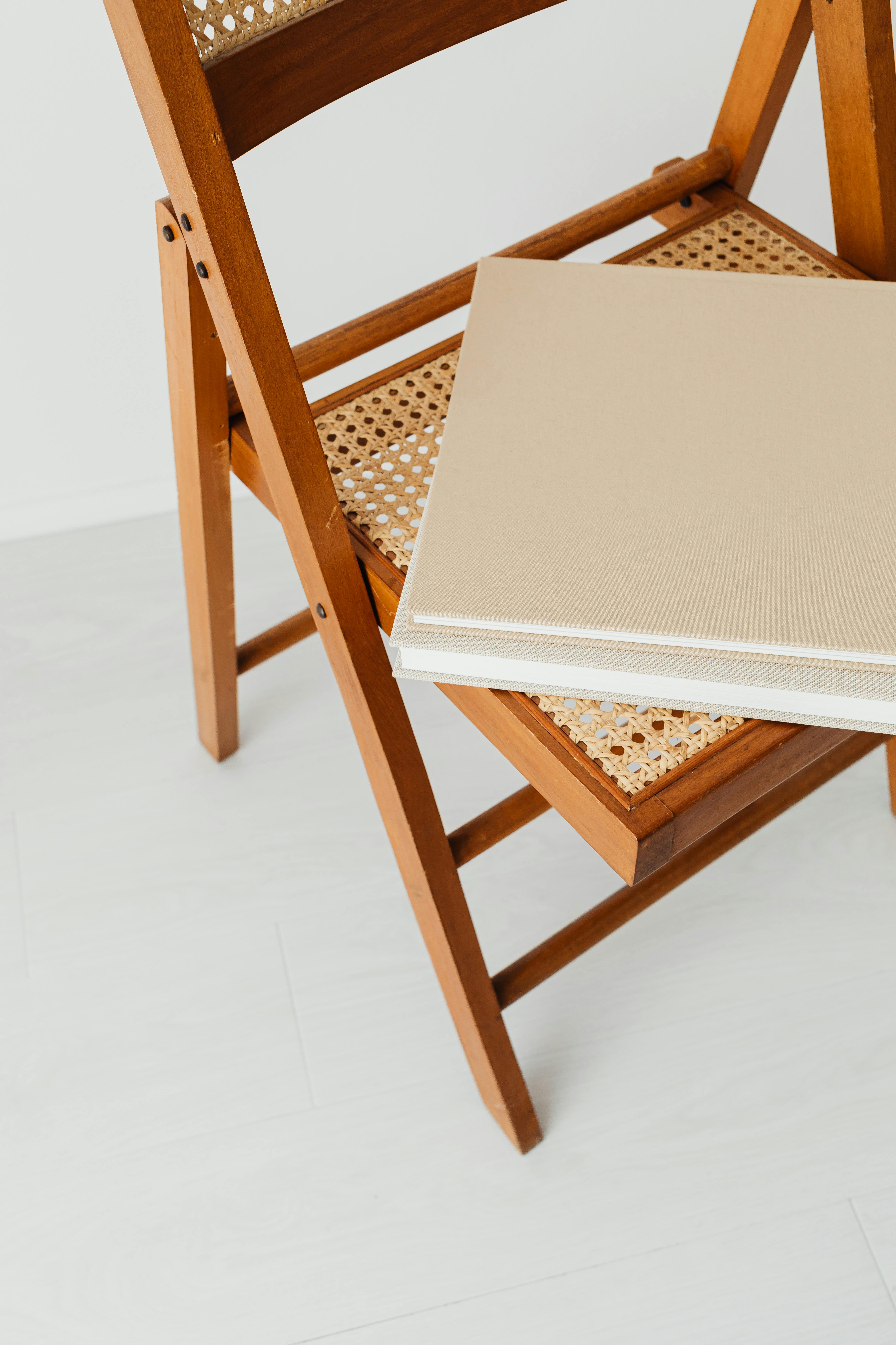 white books on top of brown folding chair