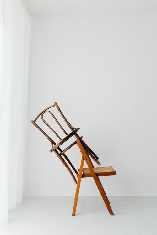 Free Elegant and modern stacked wooden chairs against a white backdrop, showcasing simplicity and balance. Stock Photo