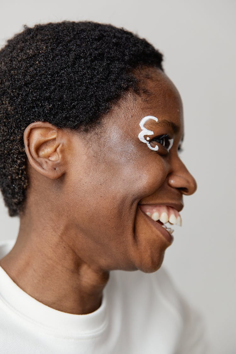 Profile Of A Smiling Woman With Short Black Hair And White Face Paint