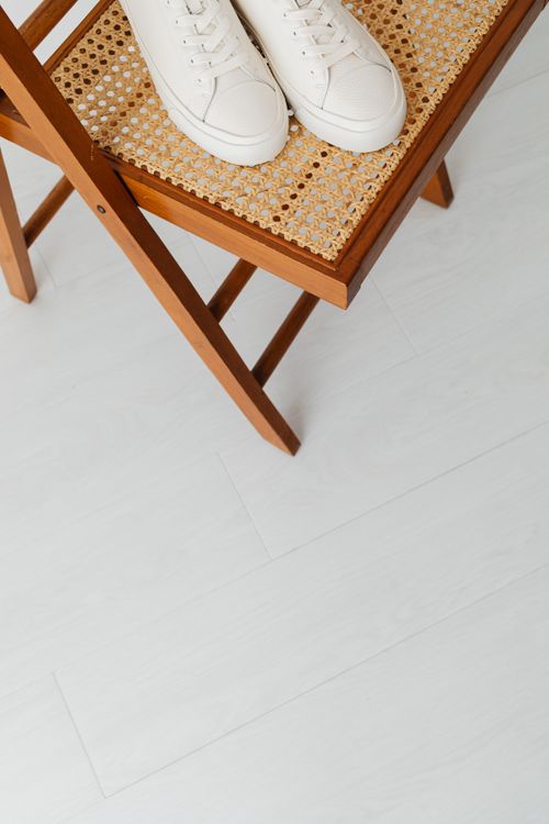 Free Stylish white sneakers placed on a wooden chair against a light floor. Minimalist and simple composition. Stock Photo