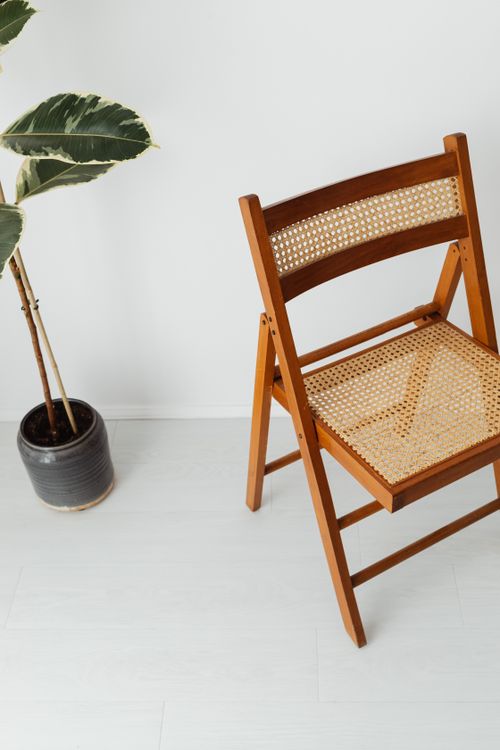 Free Cozy minimalist interior featuring a wooden chair and potted plant on a light background. Stock Photo