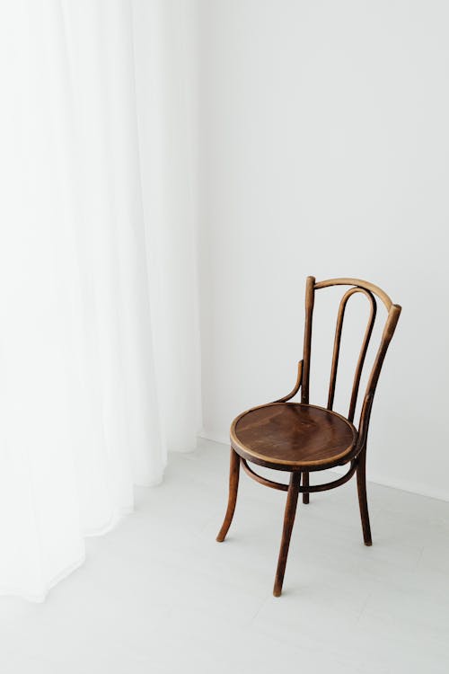 Free Brown Wooden Chair Beside White Curtains Stock Photo