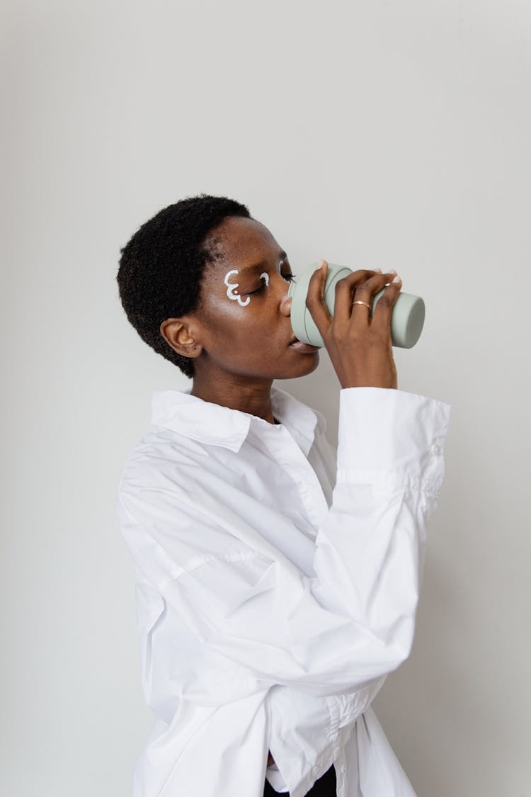 Woman In White Long Sleeves Shirt Drinking From A Tumbler