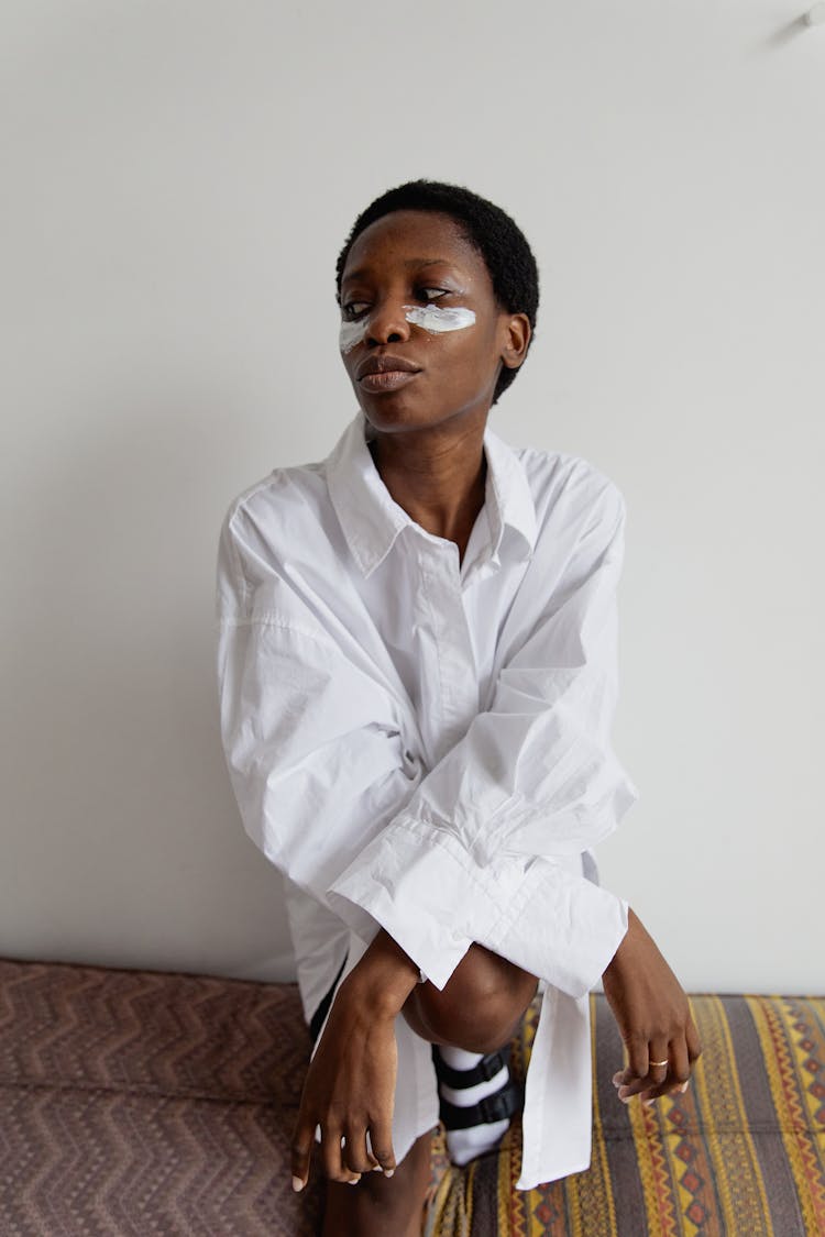 Young Woman Sitting On A Daybed