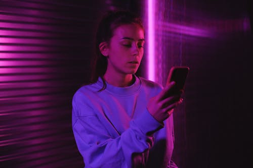 Woman in Purple Sweater Using Mobile Phone