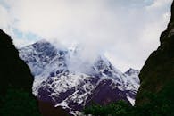 云层笼罩着令人惊叹的山峰，捕捉到大自然的原始美丽